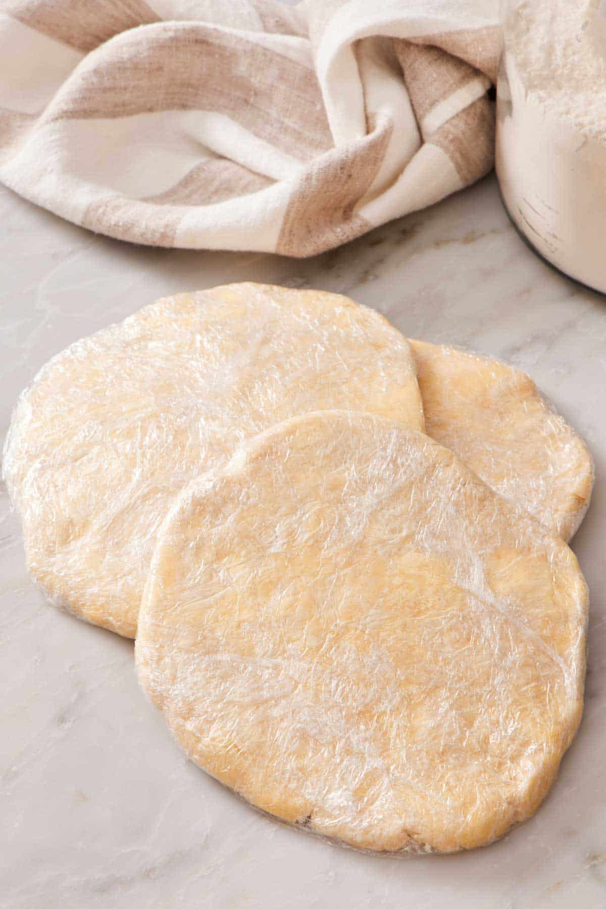 Three pie dough discs ready for freezing.