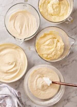 Overhead shot of several cake batters in containers that used different mixing methods.