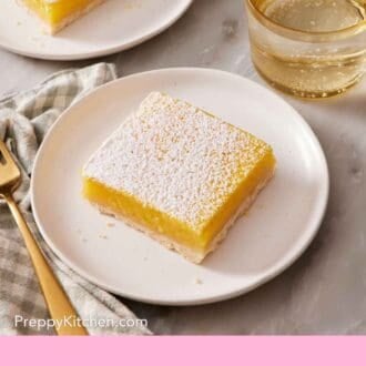 Pinterest graphic showing two lemon bars on two plates alongside a beverage.