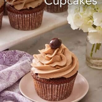 Pinterest graphic showing a mocha cupcake on a small plate with more cupcakes on a raised surface behind it, and a vase of flowers.