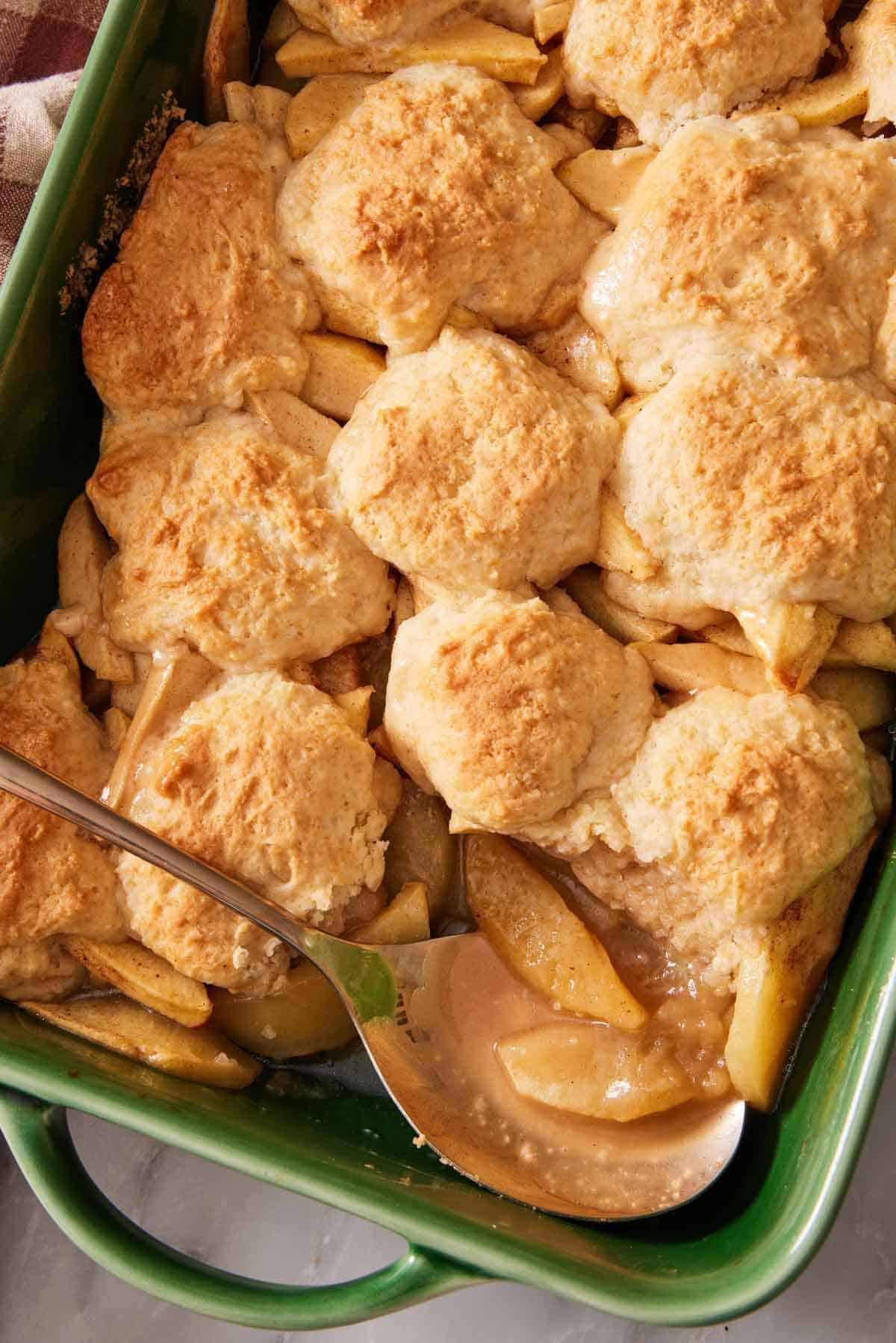 Overhead shot of apple cobbler in a green casserole dish.