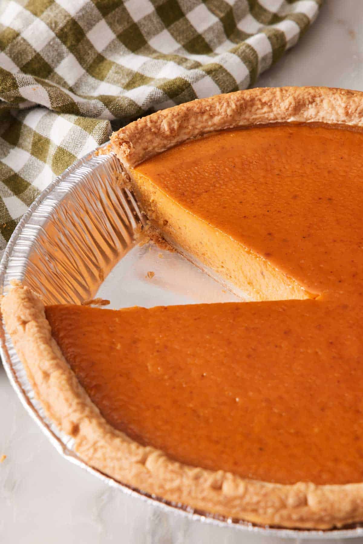 Pumpkin pie baked from frozen with a slice cut out.