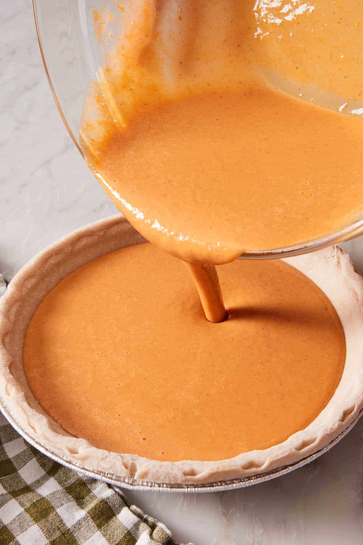 Homemade pumpkin pie filling poured into a crust.
