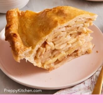 Pinterest graphic showing a side view of a slice of apple pie on a plate with a cup of coffee.