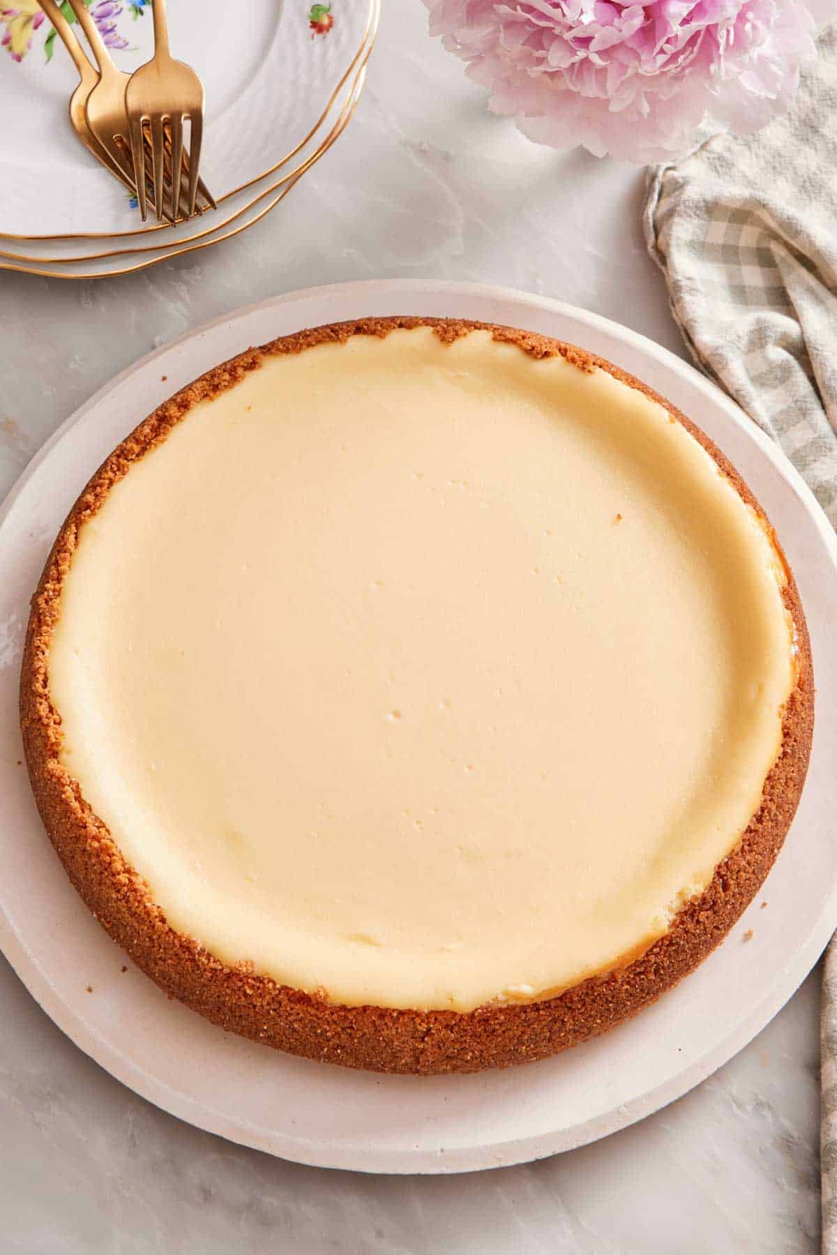 A whole cheesecake on a large plate.