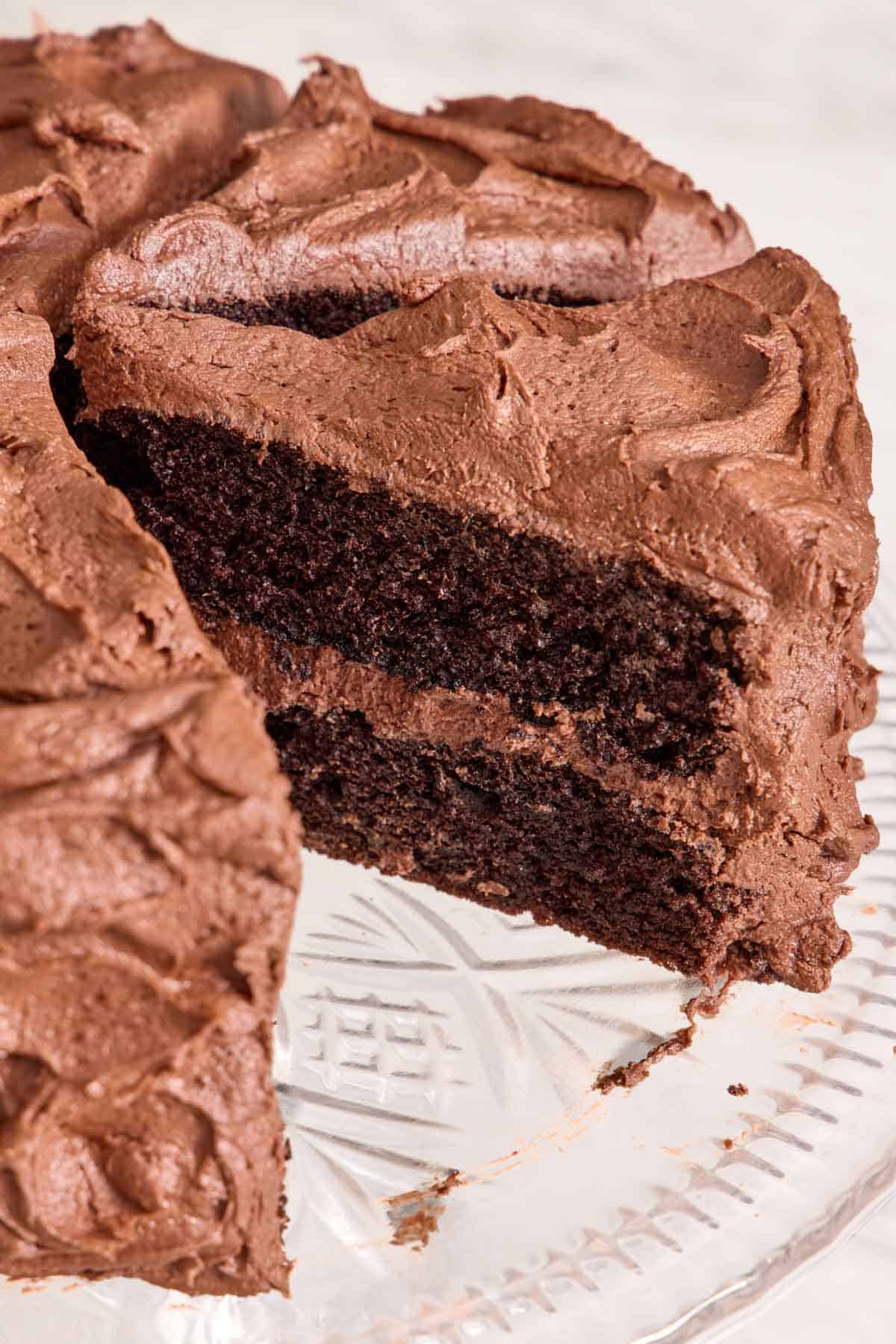 Close-up of a chocolate cake with a slice cut out.
