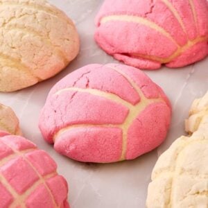 Several conchas, some pink and some plain, on a marble countertop.