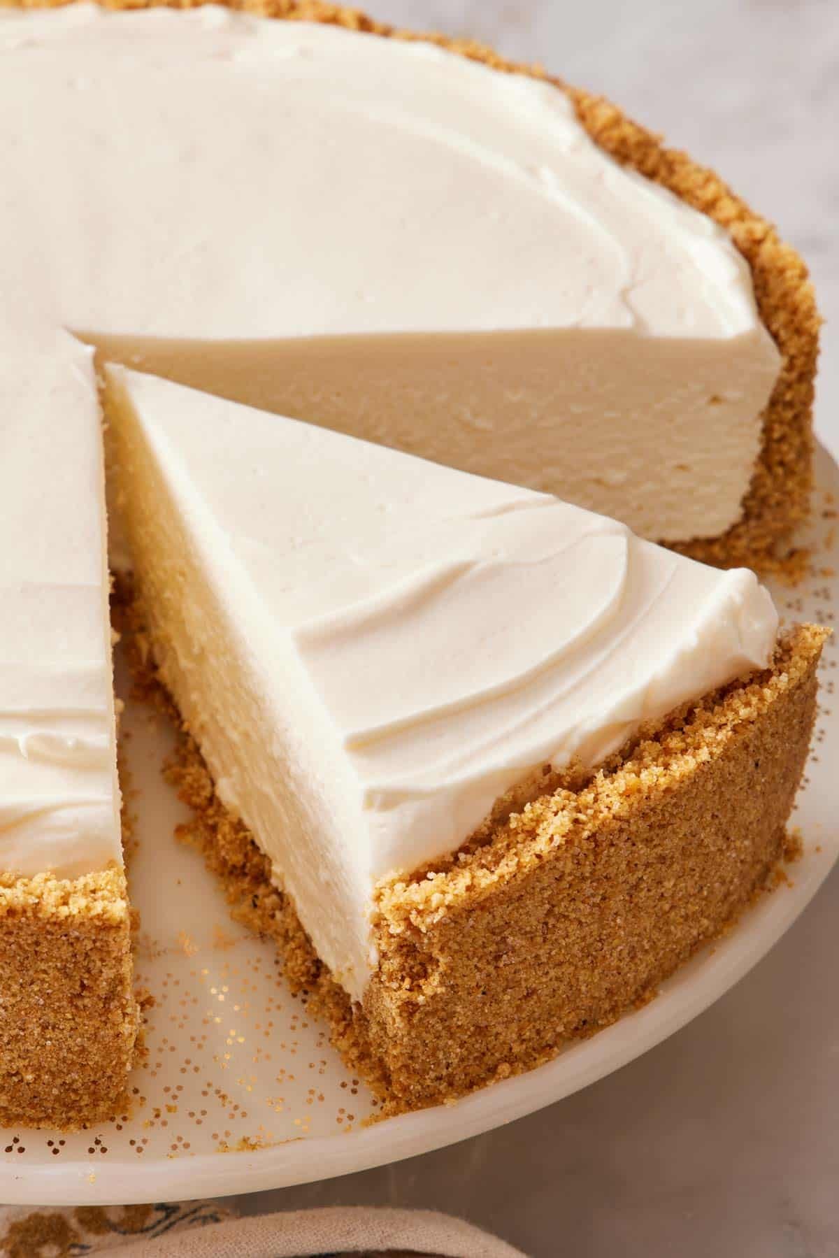 Close-up of a no-bake cheesecake slice still with the rest of the whole cheesecake.