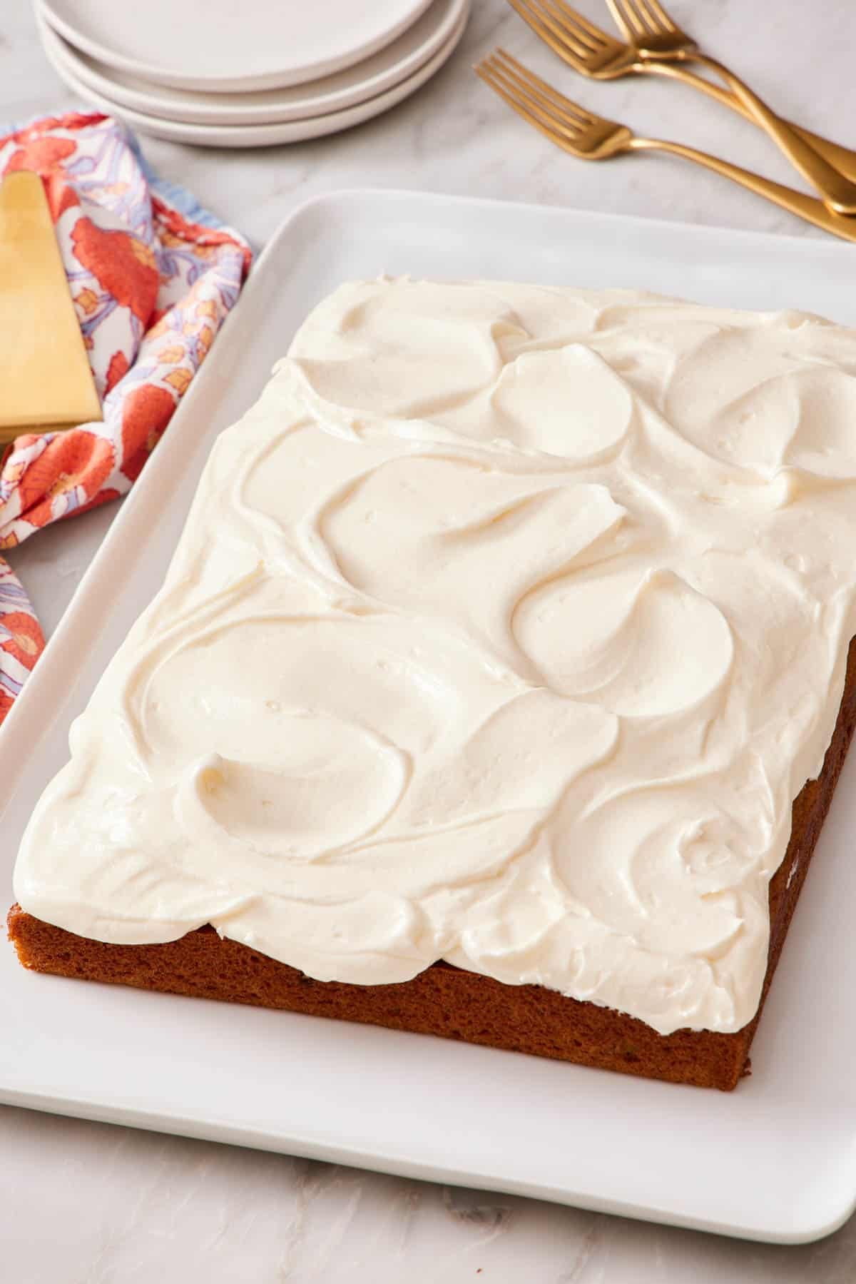 An entire frosted pumpkin cake on a large tray.