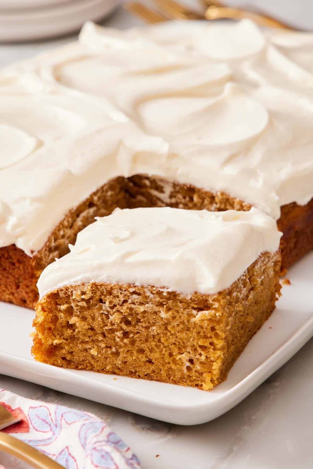 Close up of a slice of pumpkin cake pulled slightly away from the rest of the cake.