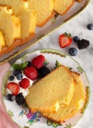 Overhead view of a plate with two slices of pound cake with berries and whipped cream.