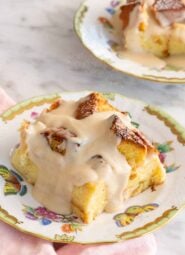 A plate with a serving of bread pudding with a second one in the background, slightly out of frame.
